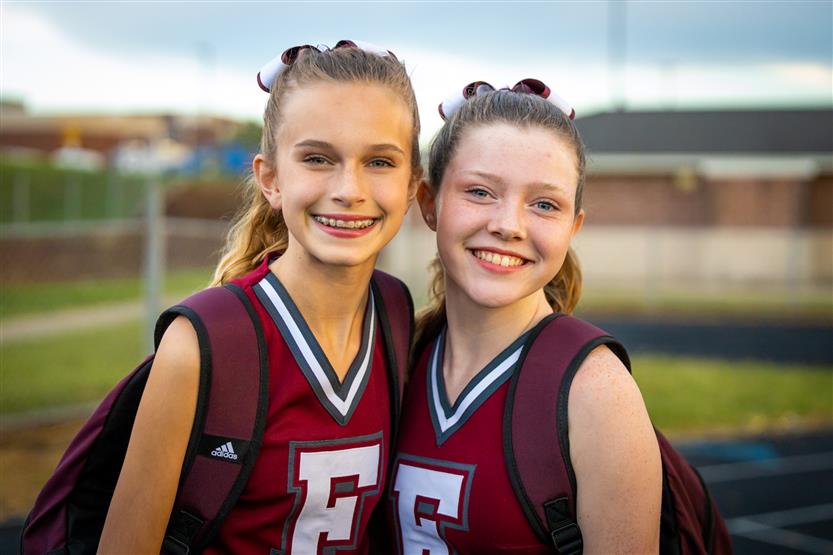 Two cheerleaders smile